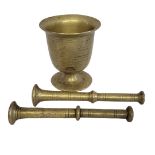 A LATE 19TH/EARLY 20TH CENTURY SOLID CAST BRASS MORTAR AND TWO PESTLES Raised on a circular
