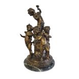 A 20TH CENTURY CONTINENTAL PATINATED GROUP OF BACCHANALIAN FIGURAL GROUP OF CHERUBS IN THE MANNER OF