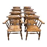 A SET OF EIGHT SOLID ELM VICTORIAN STYLE CAPTAINS CHAIRS With turned roman spindles, pierced heart