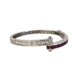 AN 18CT WHITE GOLD DIAMOND AND RUBY BANGLE Opposing rows of baguette cut diamonds and princess cut