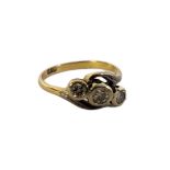 AN EARLY 20TH CENTURY 18CT GOLD AND THREE STONE DIAMOND RING Graduated stones in a half twist