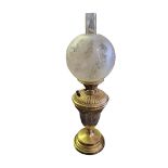 A LATE VICTORIAN GILDED BRASS OIL LAMP Embossed Neoclassical shape, raised on solid metal and gilded