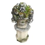 A RECONSTITUTED STONE GARDEN ORNAMENT IN THE FORM OF A BASKET OF FRUIT On a plinth. (83cm)