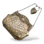 AN EARLY 20TH CENTURY SILVER PURSE Having an embossed floral decoration to frame with faux crocodile