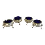 CATCHPOLE AND WILLIAMS, A SET OF FOUR EARLY 20TH CENTURY SILVER AND BLUE GLASS CIRCULAR SALTS With