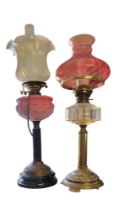 A LATE VICTORIAN GILDED BRASS OIL LAMP With Queen’s Burmese glass reservoir, raised on Corinthian