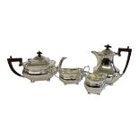 AN EARLY 20TH CENTURY SILVER TEA SET Having carved wooden finials and fluted decoration to body,