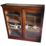 A VICTORIAN MAHOGANY FLOOR STANDING BOOKCASE With two arched glazed doors enclosing shelves, on a