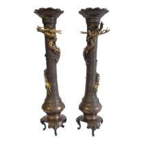 A PAIR OF 19TH CENTURY JAPANESE MEIJI BRONZE DRAGON CANDLESTICKS Having scalloped sconces and