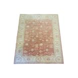 A PERSIAN WOOLLEN RUG Hand woven with floral decoration on amber central field on oatmeal cream