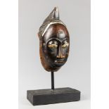 AN EARLY 20TH CENTURY CHOKWE MASK. In the form a young woman, with facial scared markings which