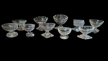 A COLLECTION OF GEORGIAN AND LATER CUT LEAD CRYSTAL OVAL GLASS SALTS With lozenge form bases. (