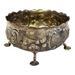 A VICTORIAN SILVER ROSE BOWL Having a scalloped edge and embossed decoration, on tripod legs,