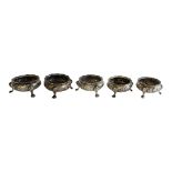 A SET OF FIVE VICTORIAN SILVER CIRCULAR SALTS With embossed decoration and tripod legs, hallmarked