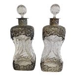 A PAIR OF VICTORIAN SILVER AND LEAD CRYSTAL DECANTERS Having spiral stoppers and overlaid with
