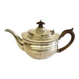 AN EDWARDIAN SILVER OVAL TEAPOT With carved wooden finial and handle, hallmarked London, 1909. (