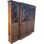 AN EARLY LARGE 19TH CENTURY MAHOGANY BREAKFRONT BOOKCASE With four aster glazed doors opening to