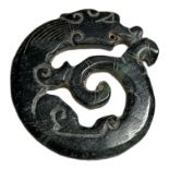 AN ORIENTAL CARVED GREEN NEPHRITE TALISMAN, POSSIBLY OF A DRAGON. (5.7cm x 5.5cm)