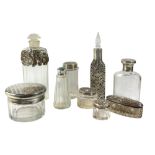 A COLLECTION OF EDWARDIAN AND LATER SILVER TOPPED & WHITE METAL GLASS SCENT BOTTLES/JARS To