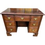 AN EARLY 19TH CENTURY MAHOGANY KNEEHOLE DESK With seven drawers and cupboard door, raised on bracket