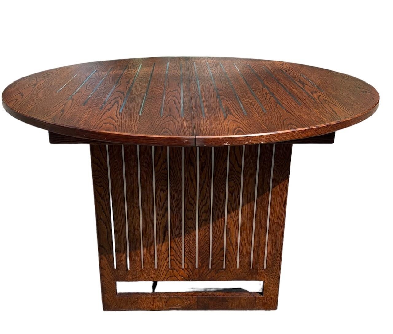 A CONTEMPORARY OAK AND STEEL INLAY DRAW LEAF DINING TABLE With single leaf, together with a matching