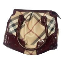 BURBERRY, A VINTAGE PATENT LEATHER AND FABRIC BARREL HANDBAG Having burgundy leather trim and fitted