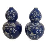 A PAIR OF CHINESE BLUE AND WHITE PORCELAIN VASES Double gourd form, decorated with prunus sprigs. (