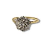 AN EARLY 20TH CENTURY YELLOW METAL AND DIAMOND CLUSTER RING Having an arrangement of round cut