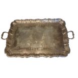 A LARGE EDWARDIAN SILVER BUTLER’S TRAY Having twin handles and scrolled edge, hallmarked Jay