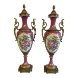 A PAIR OF 20TH CENTURY FRENCH PORCELAIN AND GILT METAL URNS Having an acorn finial, twin handles and