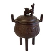 A CHINESE BRONZE CENSER AND COVER With foo dog finial above a decorated body raised on three