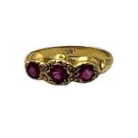 AN EARLY 20TH CENTURY 18CT GOLD AND GEM SET THREE STONE RING Having a row of three pink tone
