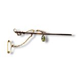 AN EARLY 20TH CENTURY 9CT GOLD AND PERIDOT BAR BROOCH Having oval cut stone in an organic mount. (