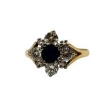 A VINTAGE 14CT GOLD, SAPPHIRE AND DIAMOND CLUSTER RING The central round cut sapphire edged with