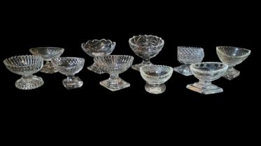 A COLLECTION OF GEORGIAN AND LATER CUT LEAD CRYSTAL OVAL GLASS SALTS With lozenge form bases,
