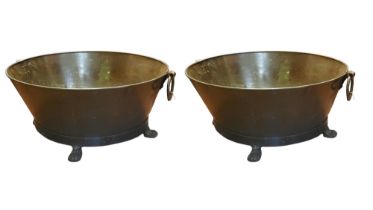 A PAIR OF IRON AND STEEL OVAL WINE COOLERS With loop handles, standing on four paw feet. (w 75cm x d