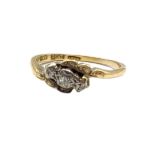 AN EARLY 20TH CENTURY 18CT GOLD AND DIAMOND THREE STONE RING Graduated stones in a half twist mount.