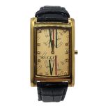 GUCCI, A VINTAGE GOLD PLATED GENT’S WRISTWATCH Rectangular form dial with Gucci monogram, on a black