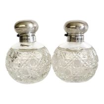 A PAIR OF 20TH CENTURY SILVER AND CUT LEAD CRYSTAL SCENT BOTTLES Having dohe form lids and hobnail