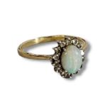 AN 18CT GOLD, OPAL AND DIAMOND RING The central cabochon cut opal,edged with round cut diamonds,