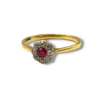 AN EARLY 20TH CENTURY 18CT GOLD, RUBY AND DIAMOND RING The central round cut ruby edged with