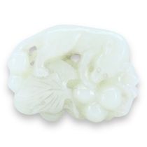 A CHINESE WHITE JADE 'SQUIRREL AND GRAPE' GROUP CARVING The pebble carved, pierced and partially