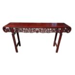 A LARGE CHINESE HARDWOOD ALTAR TABLE The plank top above a carved and priced frieze and scrolling