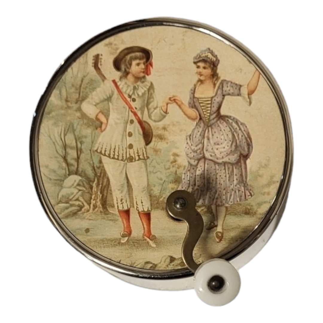 AN EDWARDIAN HAND HELD WIND UP CIRCULAR MUSICAL BOX With coloured figural print and brass winding - Image 2 of 4