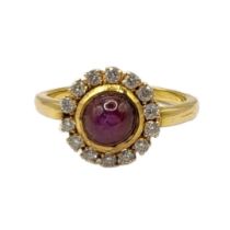 A VINTAGE YELLOW METAL, STAR RUBY AND DIAMOND AND CLUSTER RING The cabochon cut ruby edged with