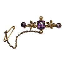 A LATE 19TH/EARLY 20TH CENTURY 15CT GOLD, AMETHYST AND MICRO SEED PEARL BAR BROOCH Set with an