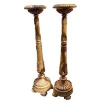 A PAIR OF 19TH CENTURY GILTWOOD AND GESSO FLOORSTANDING TORCHERES The circular tops with melon