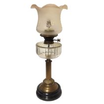 A STANDARD VICTORIAN BRASS OIL LAMP With cut glass clear reservoir, raised on a circular black base,