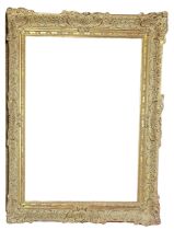 AN EARLY 20TH CENTURY GILDED RECTANGULAR PICTURE FRAME With carved scrolled decoration. (aperture