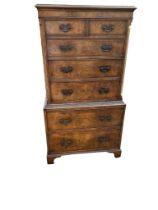 A GEORGIAN STYLE WALNUT AND MAHOGANY TALLBOY With two short above five long drawers, on bracket